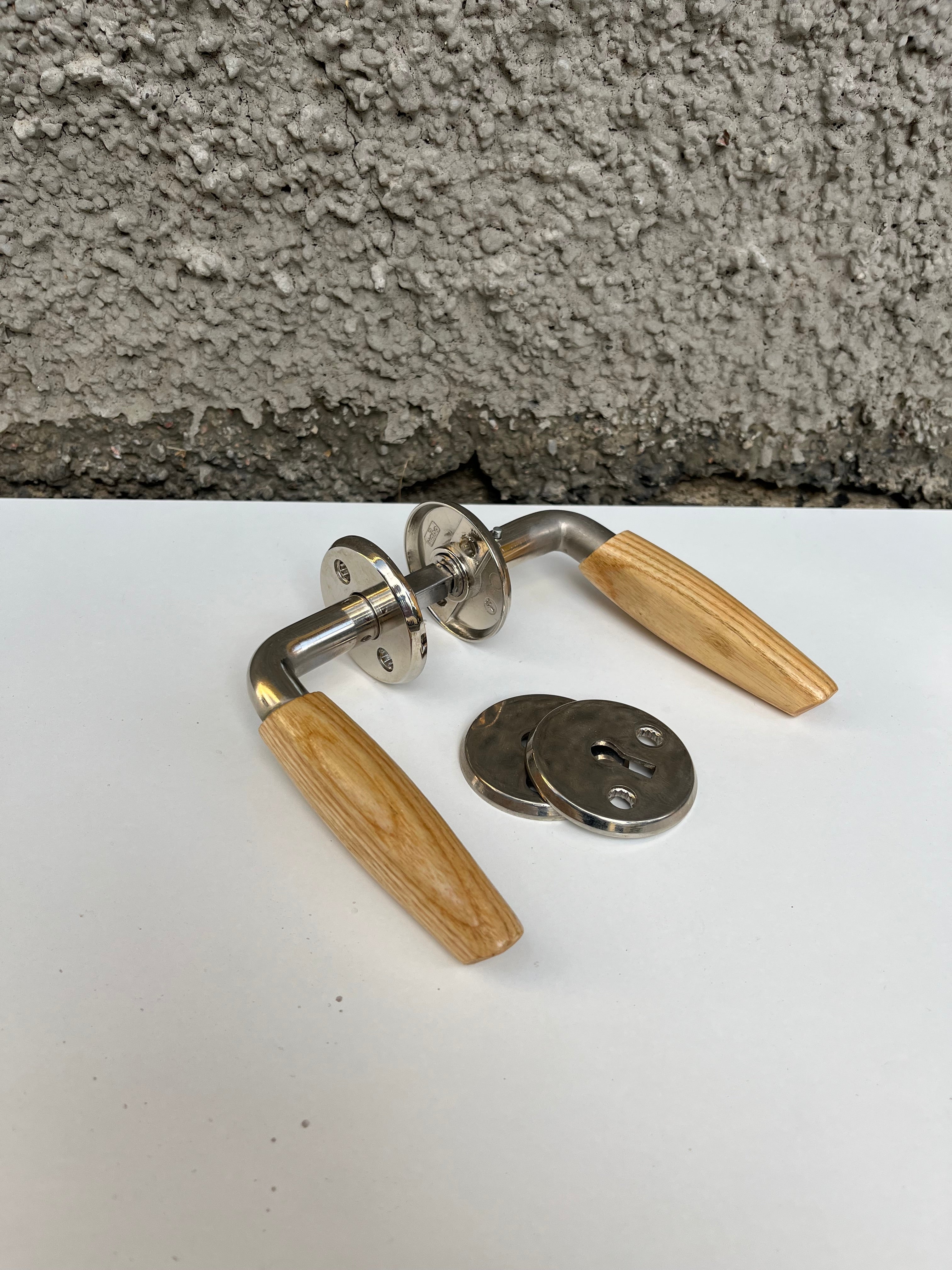 Dörrhandtag i metall med trycke i ädelträ (förmodligen ek eller ask) med tillhörande nyckelbricka