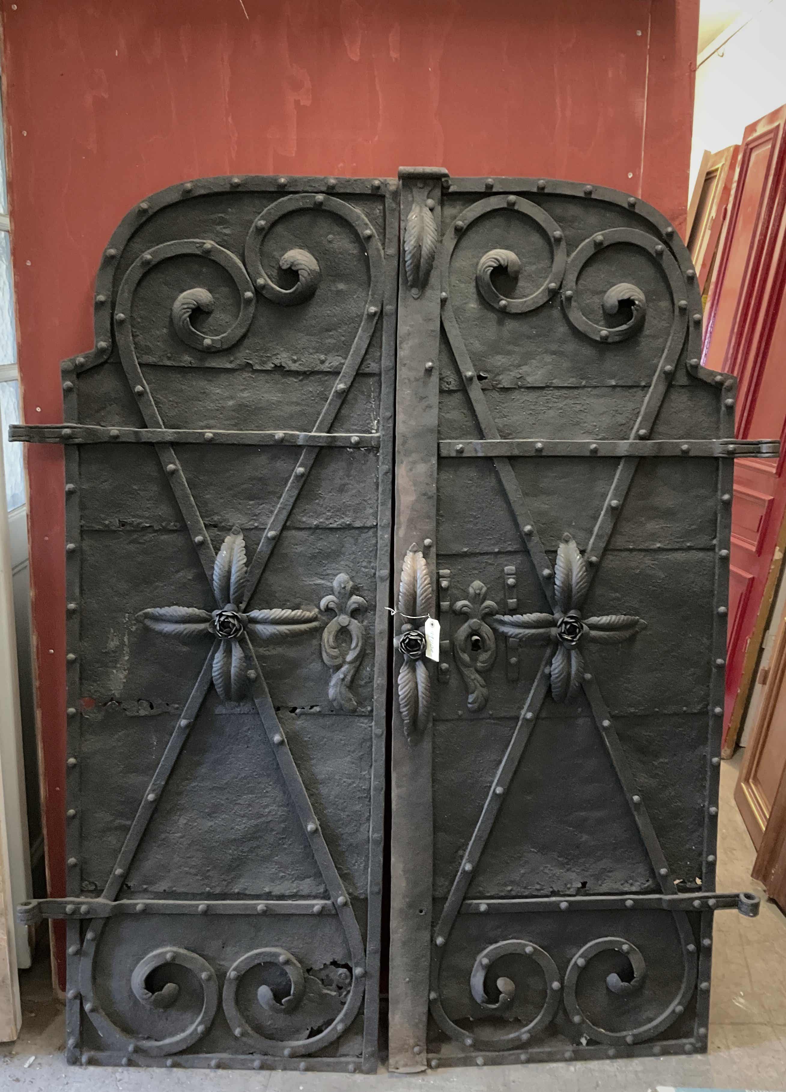 Den här porten är ett exempel på traditionellt handsmitt järnsmide, vanligt i Sverige från 1700–1800-talet. Konstruktionen består av massiva järnplåtar med genomgående bandjärn och nitar, vilket gav hög hållfasthet och lång livslängd. Dekor som voluter och rosetter är typiska inslag i historiskt smide och visar på ett avancerat hantverk. Läs mer: Att tänka på vid återbruk av spegeldörrar Så byggde vi på 1800-talet